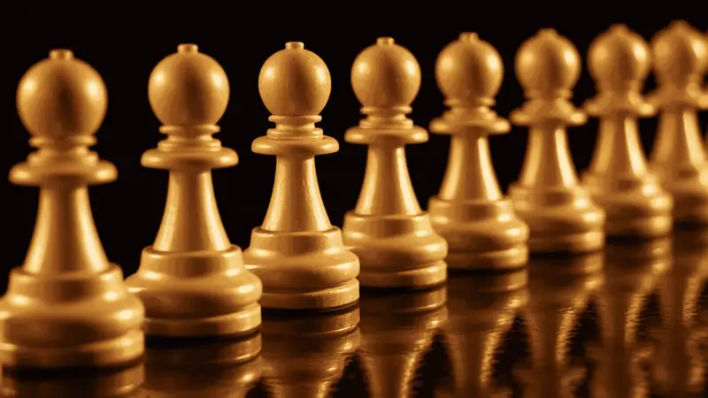 Rij witte schaakpionnen op een donkere achtergrond, symbool voor strategie en structuur in het schaakspel.